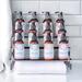 Twelve luxurious aromatherapy lotion bottles by Whole Self Aromatherapy displayed on an acrylic stand with soft white spa towel to the left.